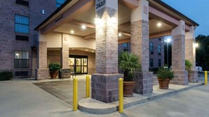 A hotel entrance with a brick facade, numbered 2620, and a covered entrance area with potted plants.