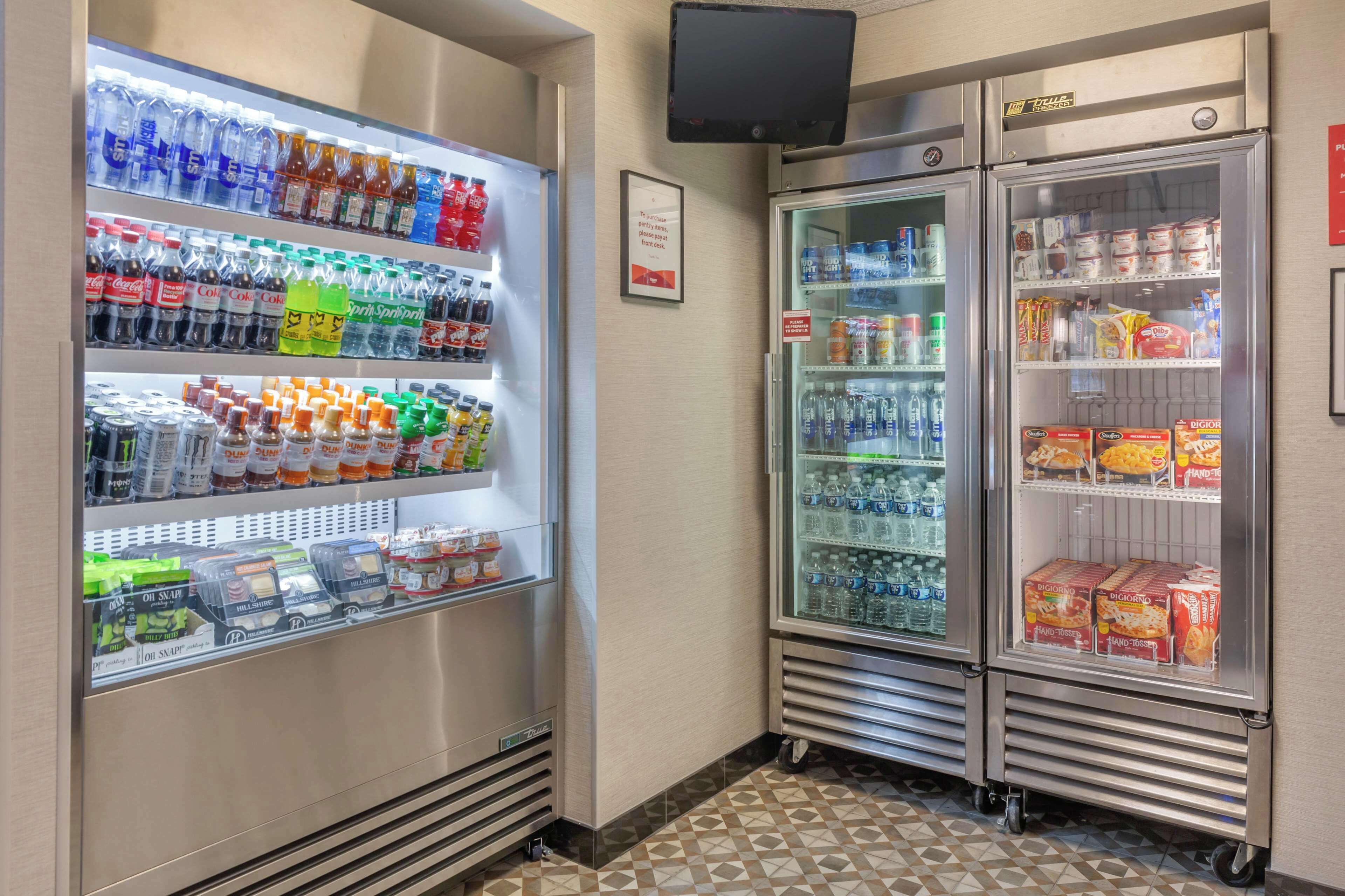 A vending area with various beverage and snack options, including bottled water, soda, and snacks.