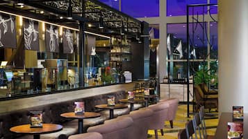 A modern bar area with leather seating and a glass partition.