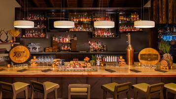 Un bar con varias botellas de licor, un barril de whisky y un alambique de cobre. Hay taburetes de bar y un cartel que indica que el bar está reservado.