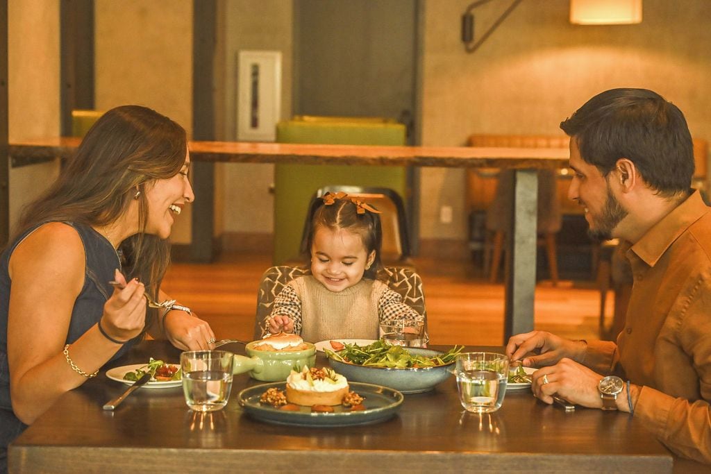 A family dining at a table with various dishes and drinks.