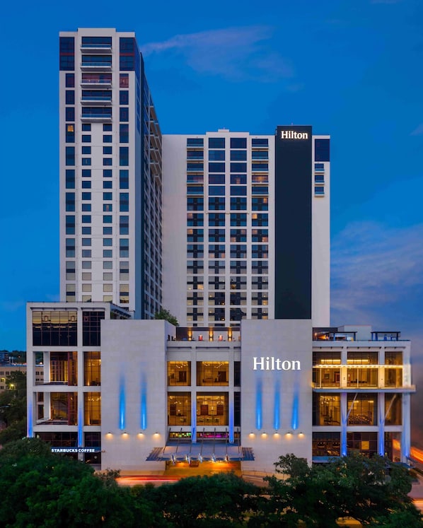 A Hilton hotel with a modern design, multiple floors, and a prominent sign.