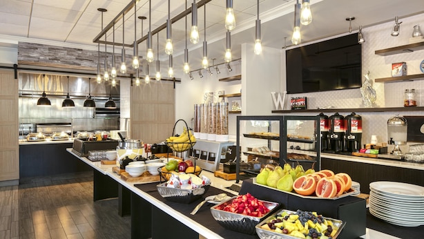 Una cocina moderna con un montaje tipo buffet, que incluye diversas frutas, verduras y bebidas.