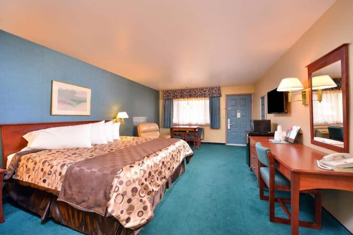 Une chambre d’hôtel équipée d’un lit, d’un bureau, d’une chaise et d’un téléviseur.