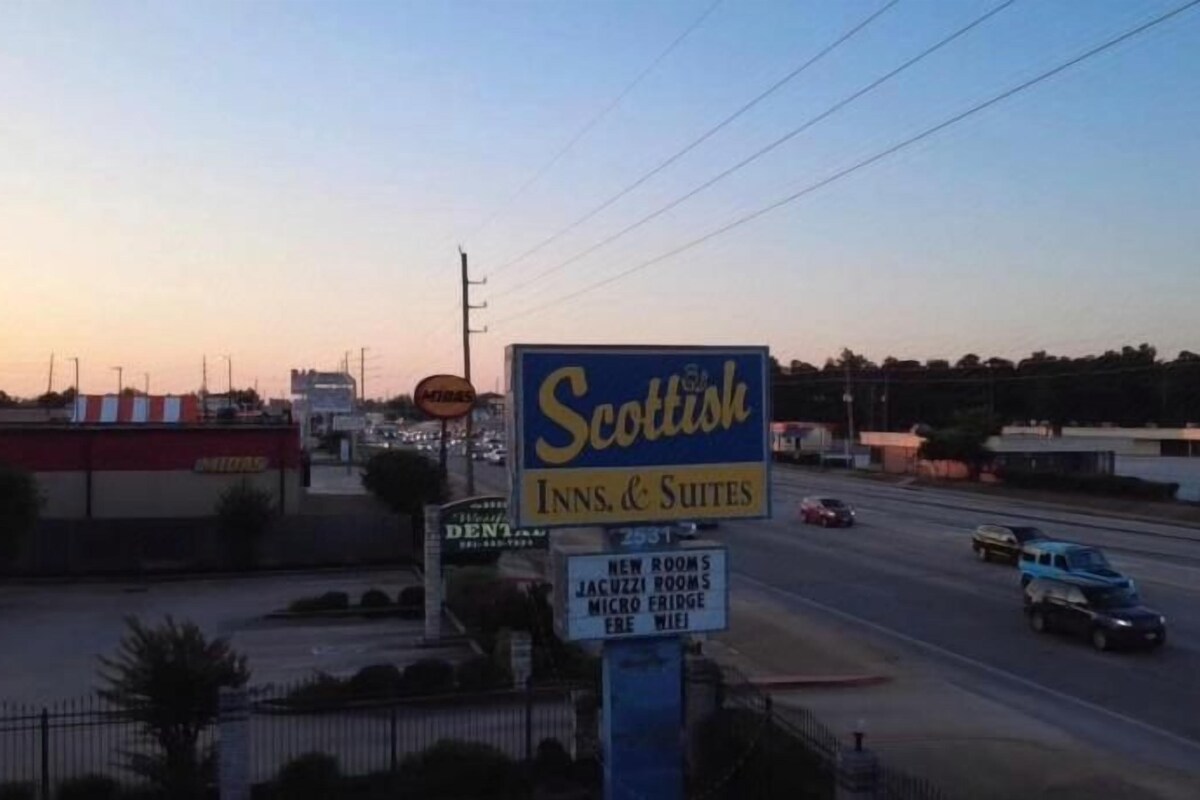 A hotel sign with the name 'Scottish Inns & Suites' and mentions new rooms, jacuzzi, and micro bridge.