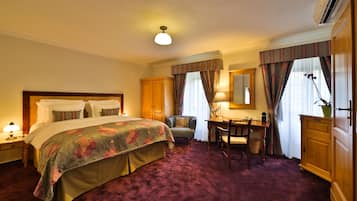 Ein Hotelzimmer mit einem Bett, einem Schreibtisch, einem Stuhl, einem Kleiderschrank und einem Spiegel.