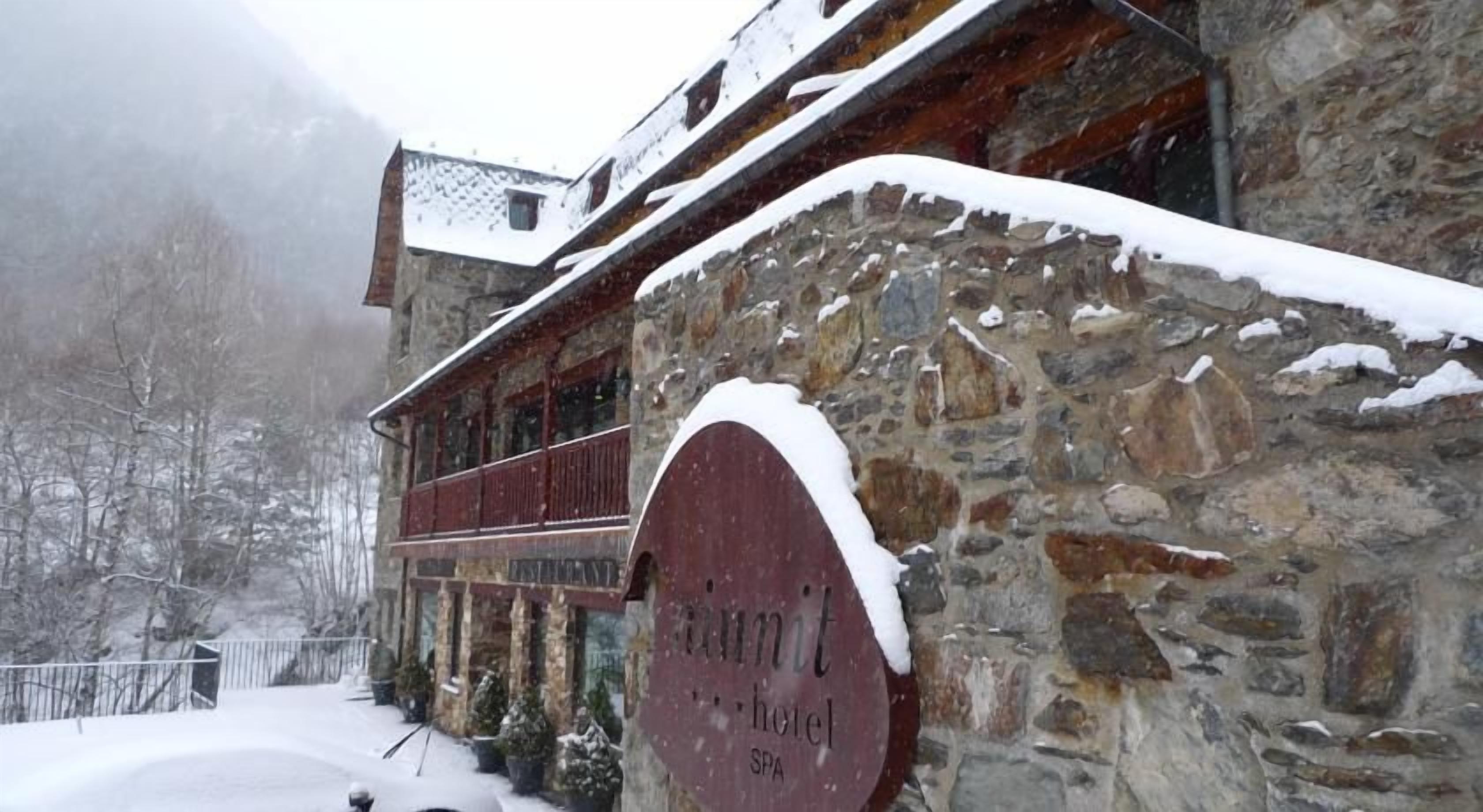 Um edifício de pedra com uma placa vermelha que diz 'Hotel'.