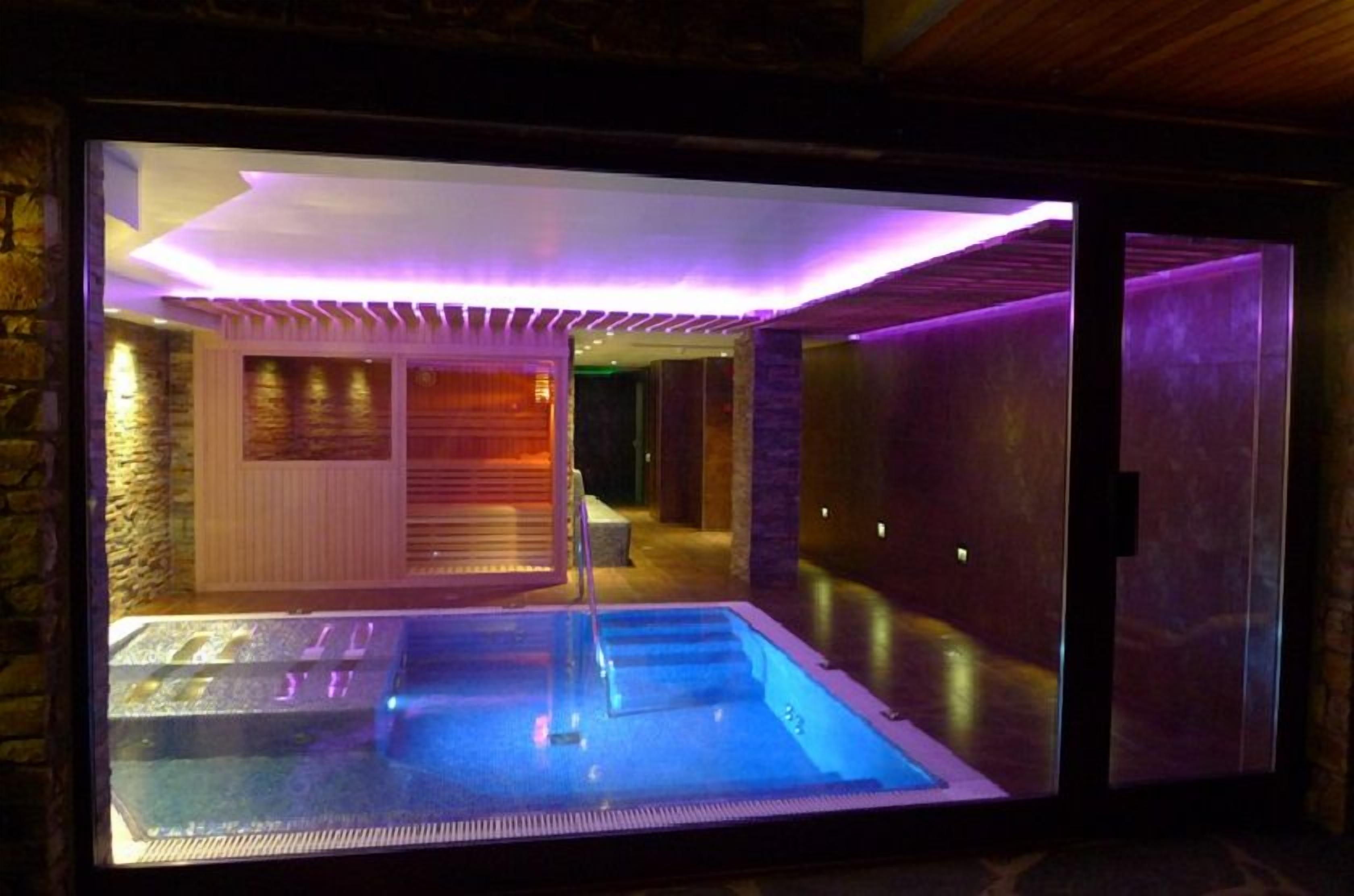 Un espace bien-être comprenant une piscine, un sauna et une salle de massage.