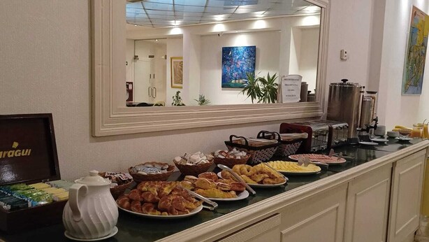 A buffet counter with various food items and a coffee station. - Atlas Tower Hotel (Buenos Aires)