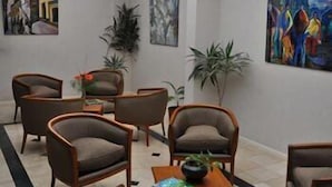 A hotel lobby with a seating area, a coffee table, and artwork on the walls. - Atlas Tower Hotel (Buenos Aires)
