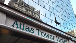 The exterior of the Atlas Tower Hotel with a modern glass facade and a sign indicating the hotel's name. - Atlas Tower Hotel (Buenos Aires)
