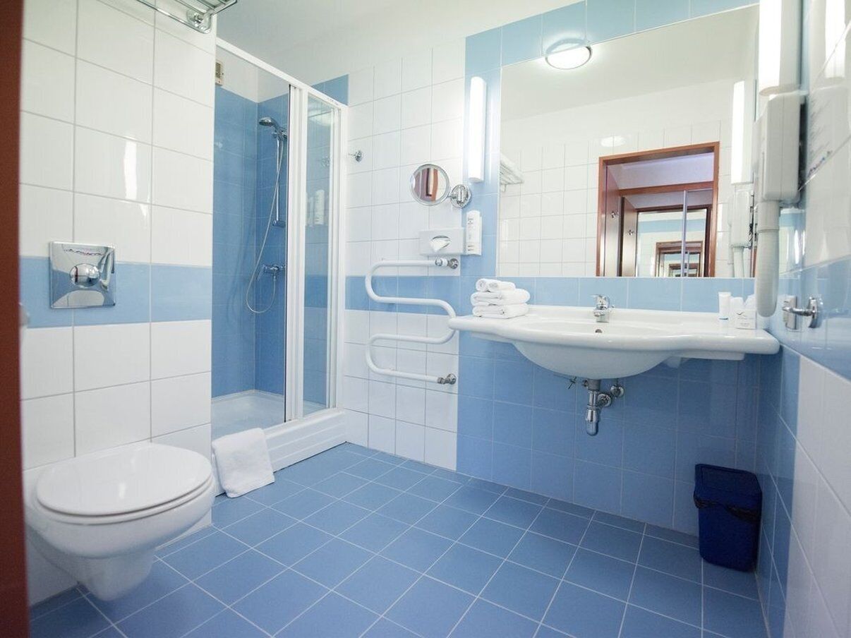 Un baño con inodoro, lavabo y ducha.