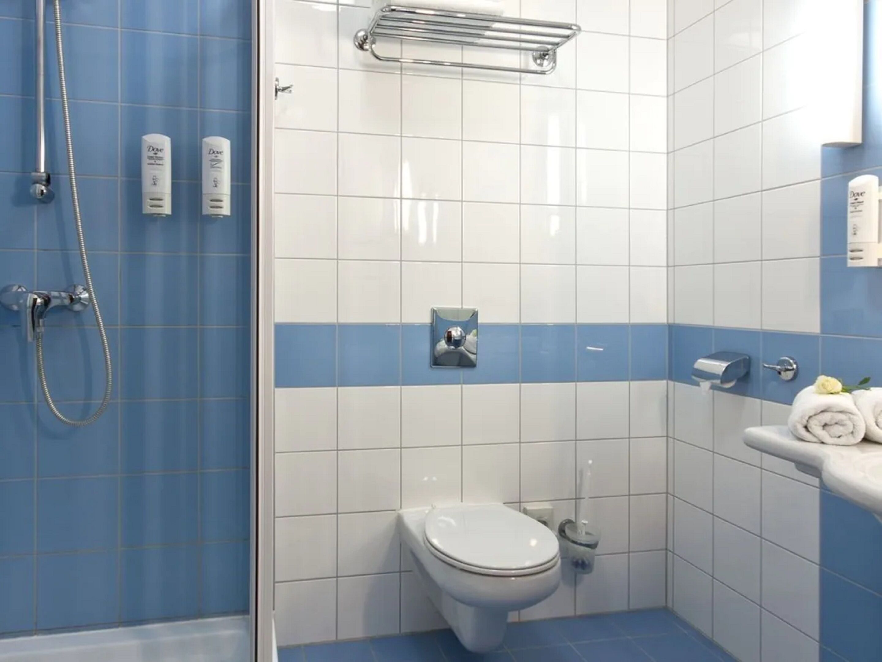 A bathroom with a shower, toilet, and sink.