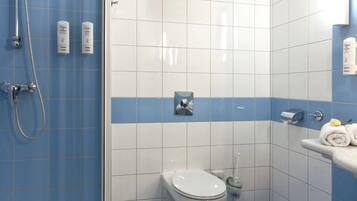 A bathroom with a shower, toilet, and sink.