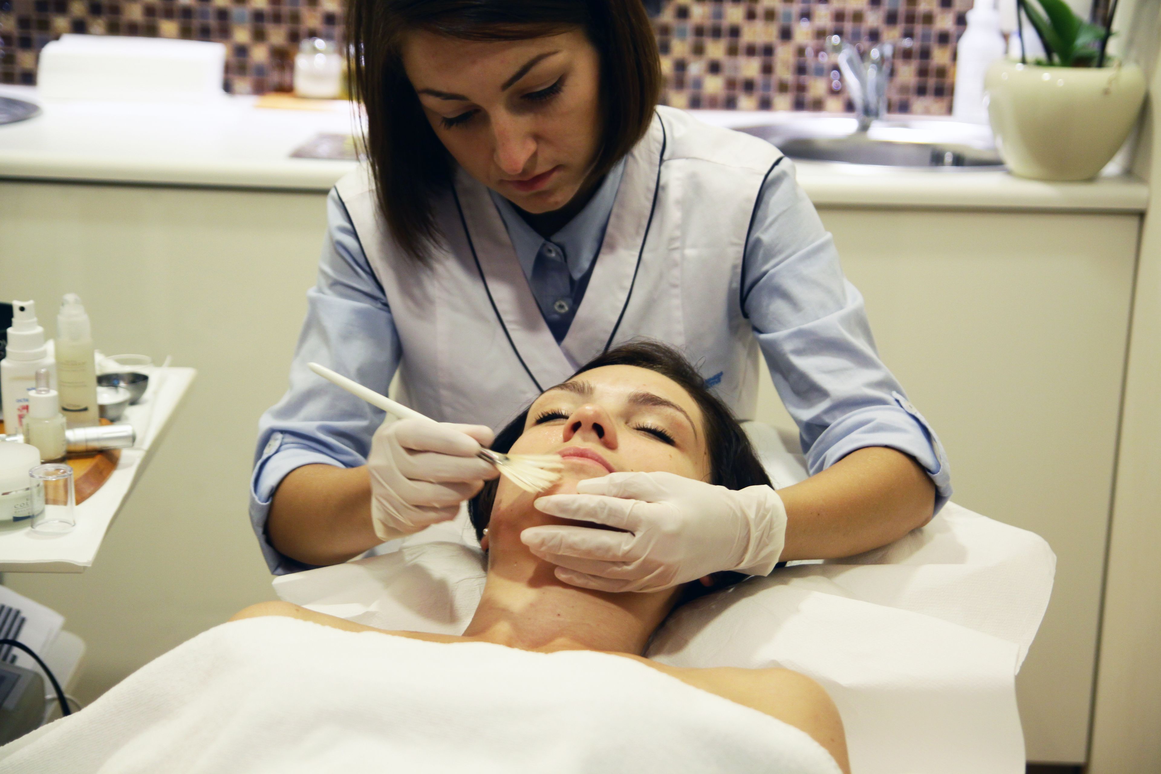 A medical professional performing a procedure on a patient in a clinical setting.