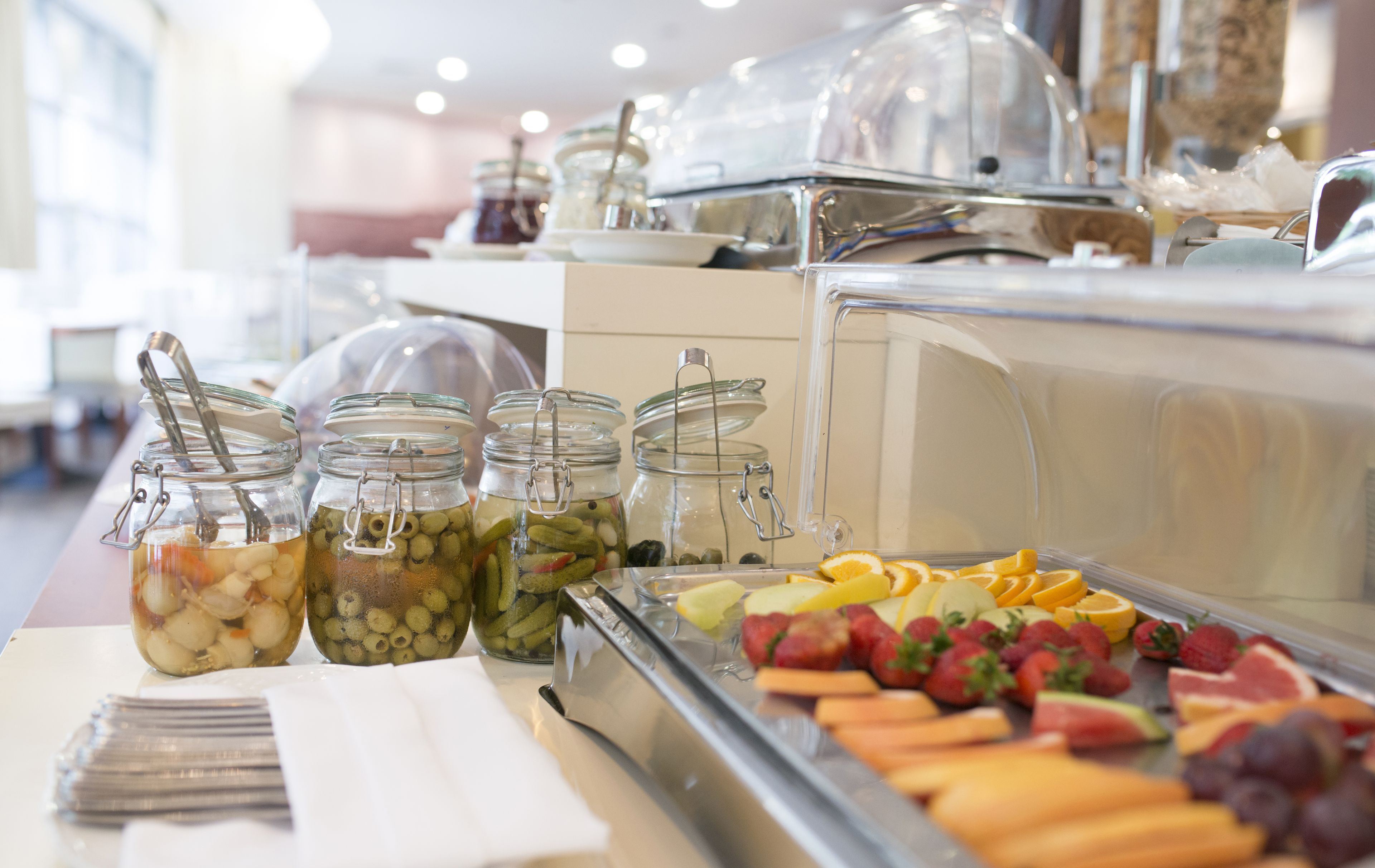 A buffet with various food items including fruits, vegetables, and pickled items.