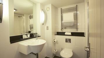 A modern bathroom with a white sink, a toilet, a mirror, and a towel rack.