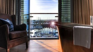 A modern room with a view of a marina through large windows. - Salthouse Harbour Hotel and Spa (Ipswich)