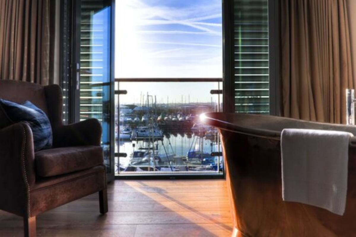 Ein modernes Zimmer mit Blick auf eine Marina durch große Fenster.