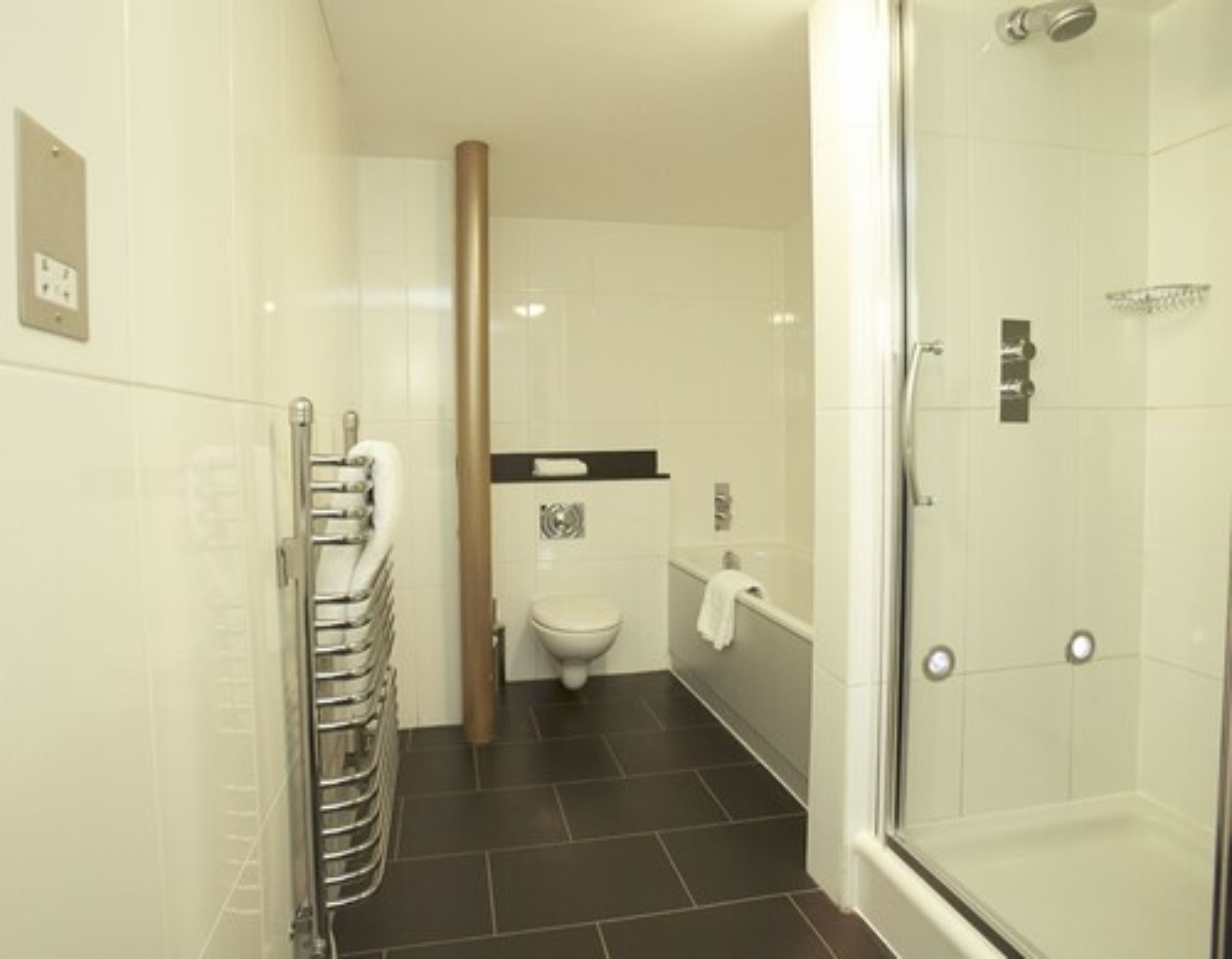 Un baño moderno con ducha de vidrio, inodoro y bañera.