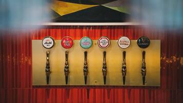 A row of beer taps with labels including 'Asahi,' 'Old Speckled Hen,' 'Guinness,' and others.