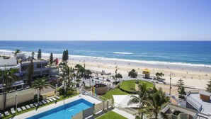 A hotel with a swimming pool, beach view, and palm trees. - Paradise Centre Apartments (Surfers Paradise)
