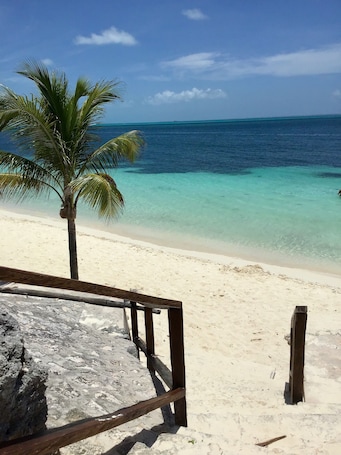 En la playa, arena blanca, sillas reclinables de playa, sombrillas. Hotel Dos Playas Faranda Cancun