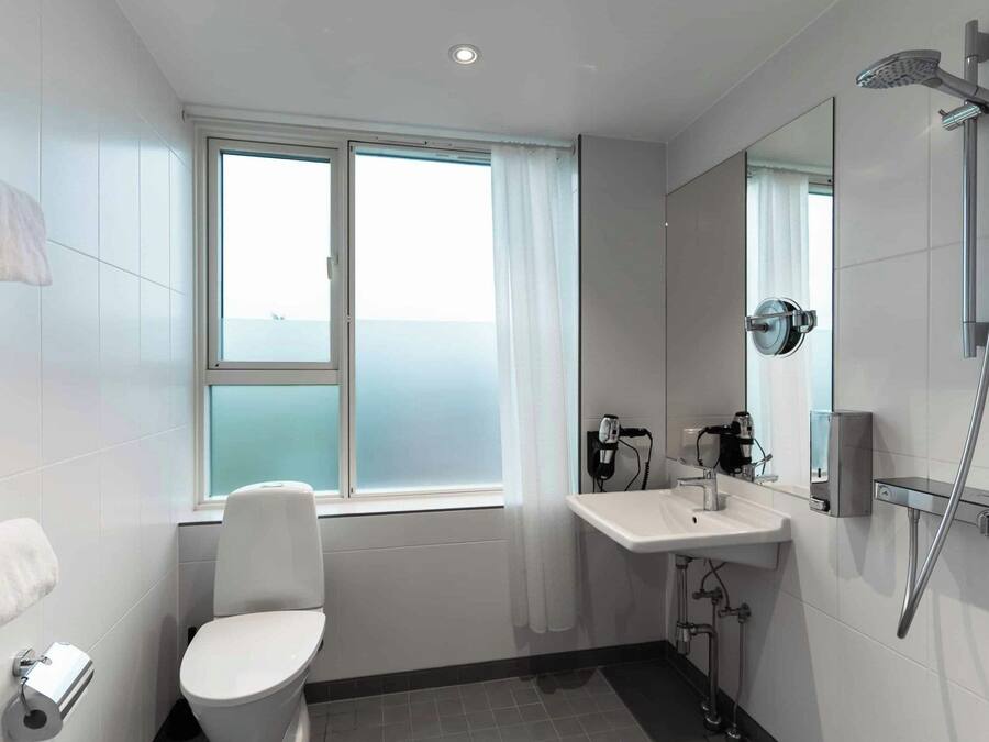 A modern bathroom with a toilet, sink, and shower.