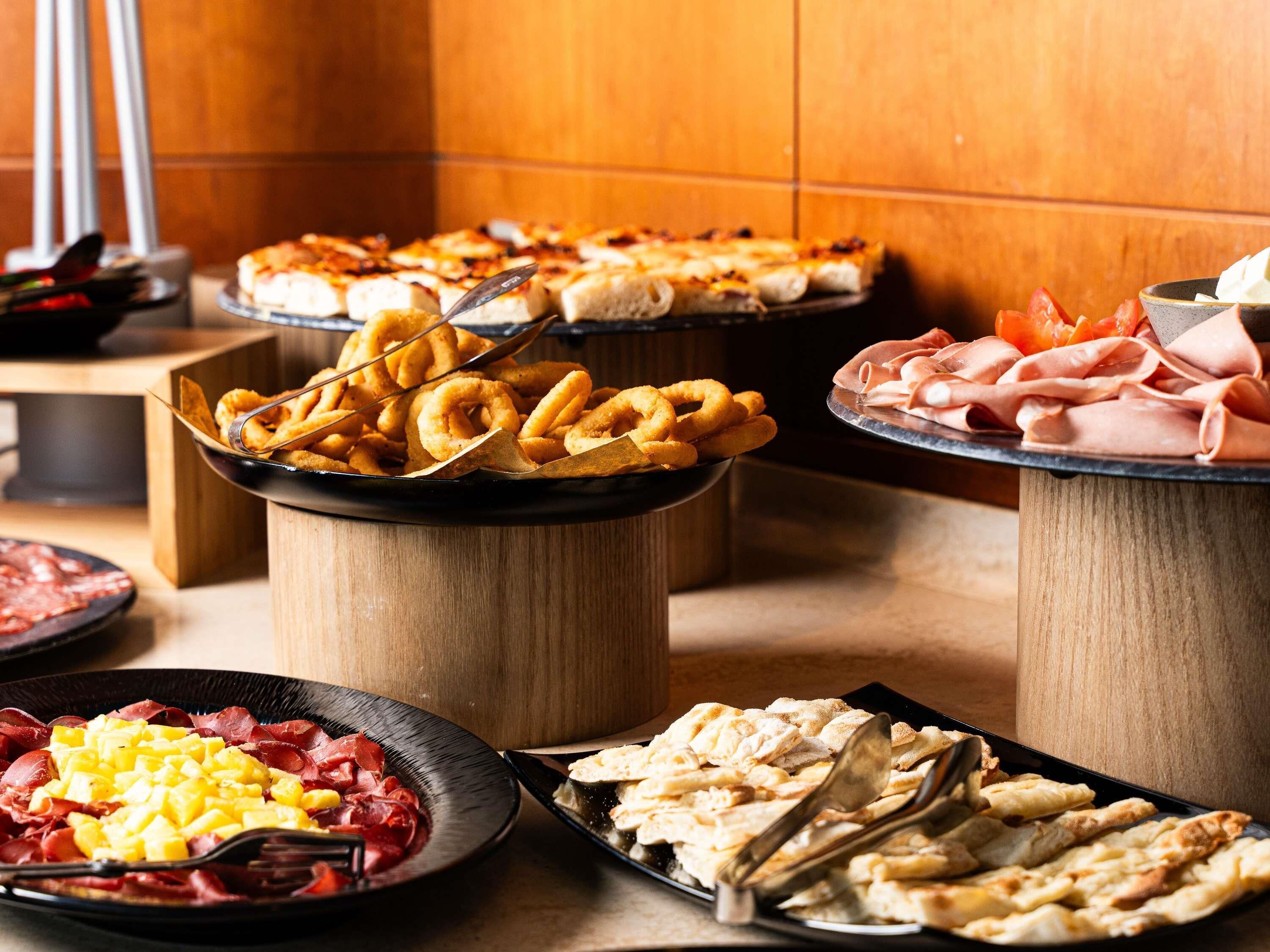 En buffet med forskellige spiser, herunder brød, kød og ost.