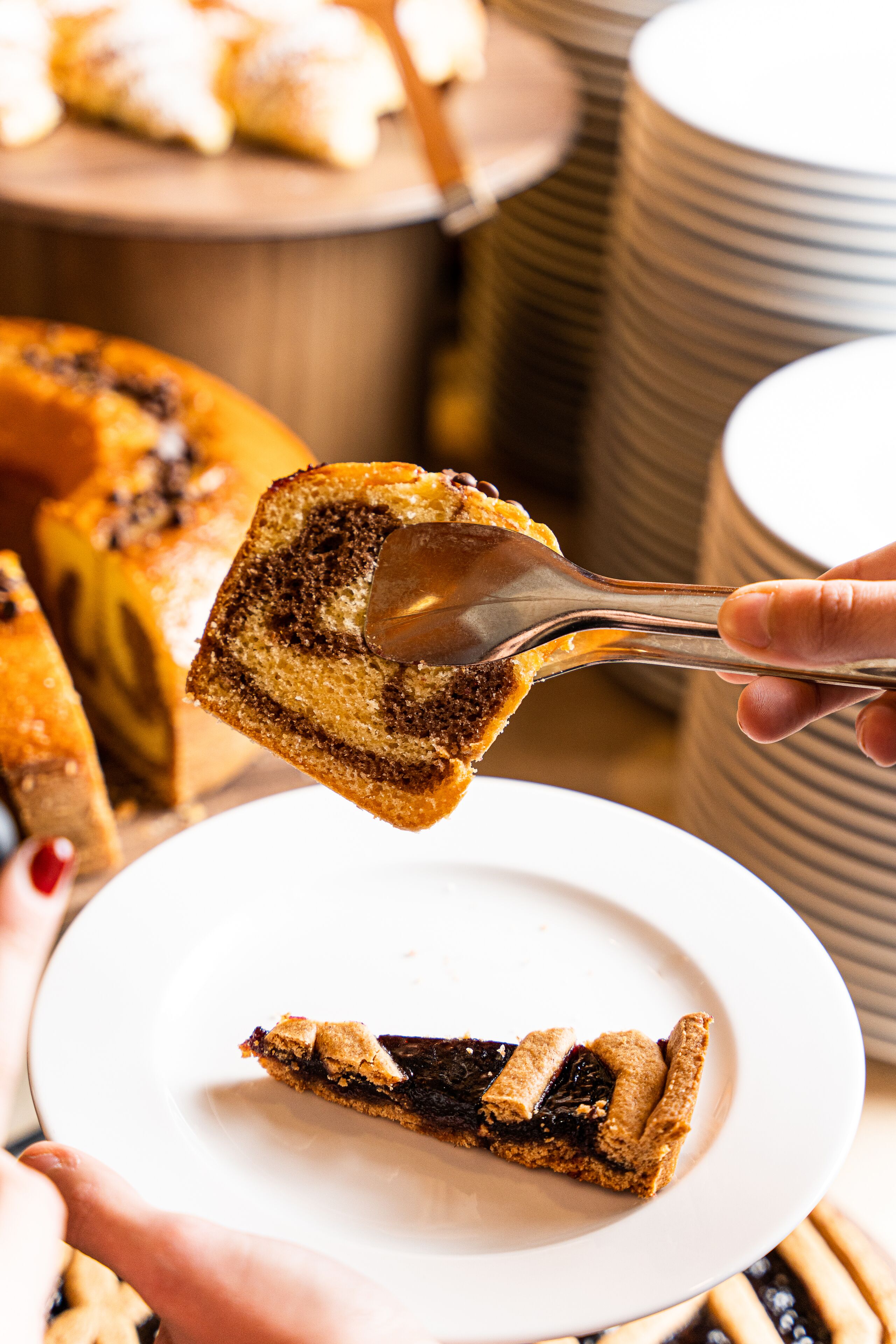 A slice of cake on a plate, with a spoon lifting a piece.