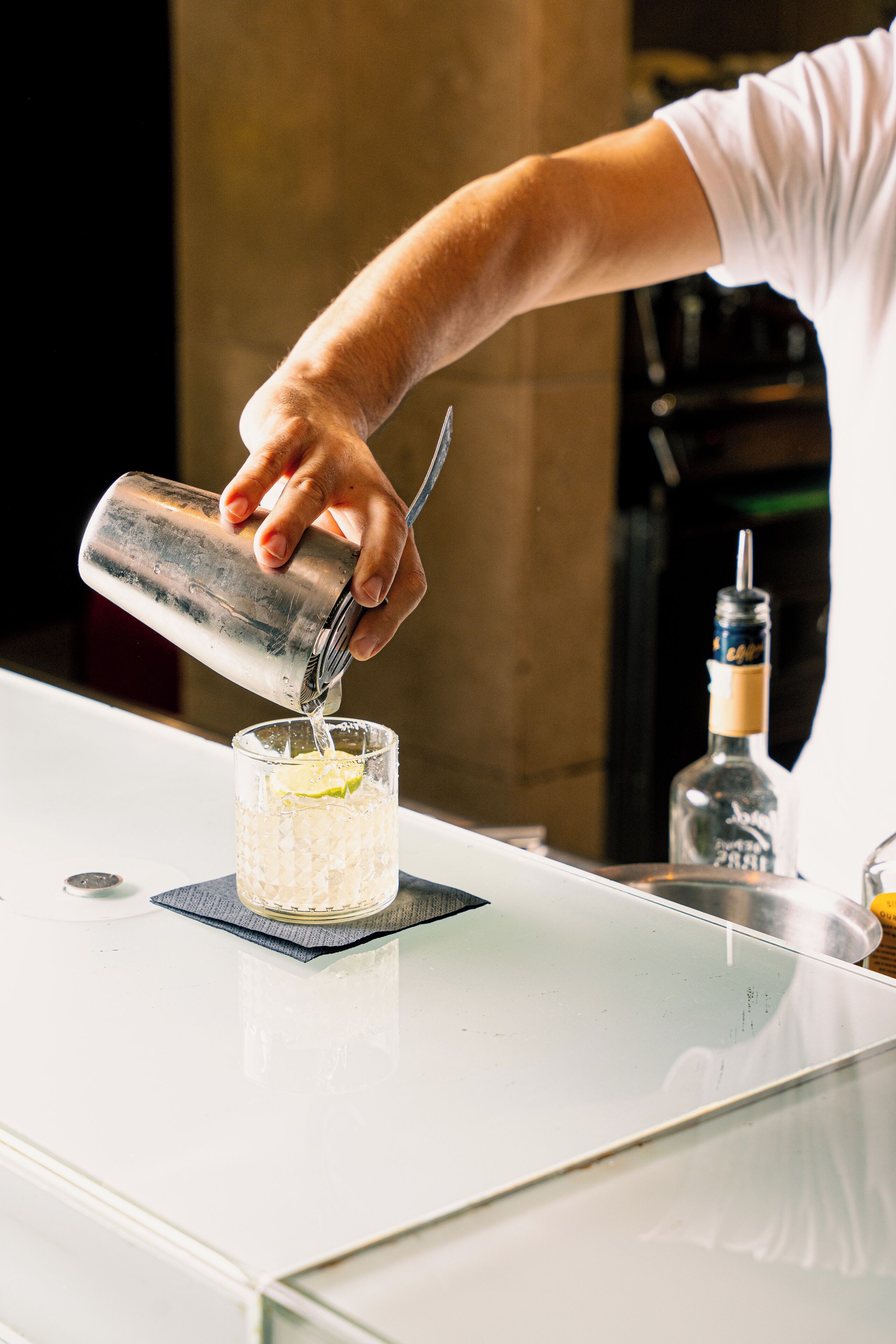 En bartender hælder en drik i et glas.