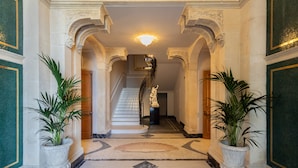 A grand hallway with a marble floor, ornate columns, and a staircase leading to an upper level. - Grand Hotel Des Ètrangers - The Leading Hotels of the World (Syracuse)