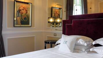 Une chambre d’hôtel avec un grand lit, un miroir, un tableau et une lampe.