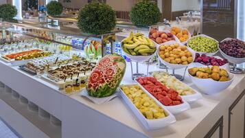 Un bufé con frutas, verduras y postres variados.