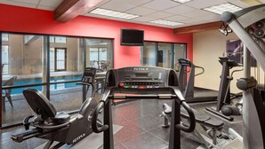 A gym with cardio equipment, a large window, and a television on the wall. - Country Inn & Suites by Radisson, Council Bluffs, IA (Council Bluffs)