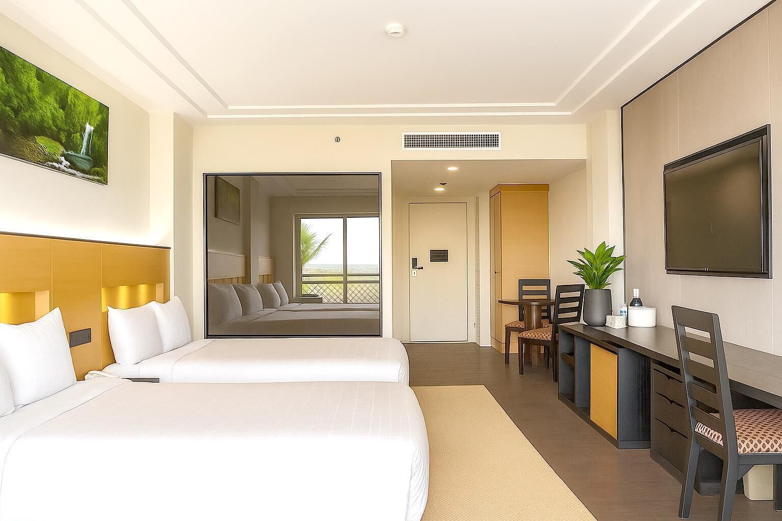 Une chambre d’hôtel avec un grand lit, un bureau avec une chaise, une télévision et une fenêtre donnant sur l’extérieur.