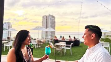 Un coin repas avec une table dressée pour deux personnes, une boisson et de la nourriture.