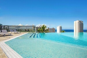 Una piscina al aire libre, sillones reclinables de piscina