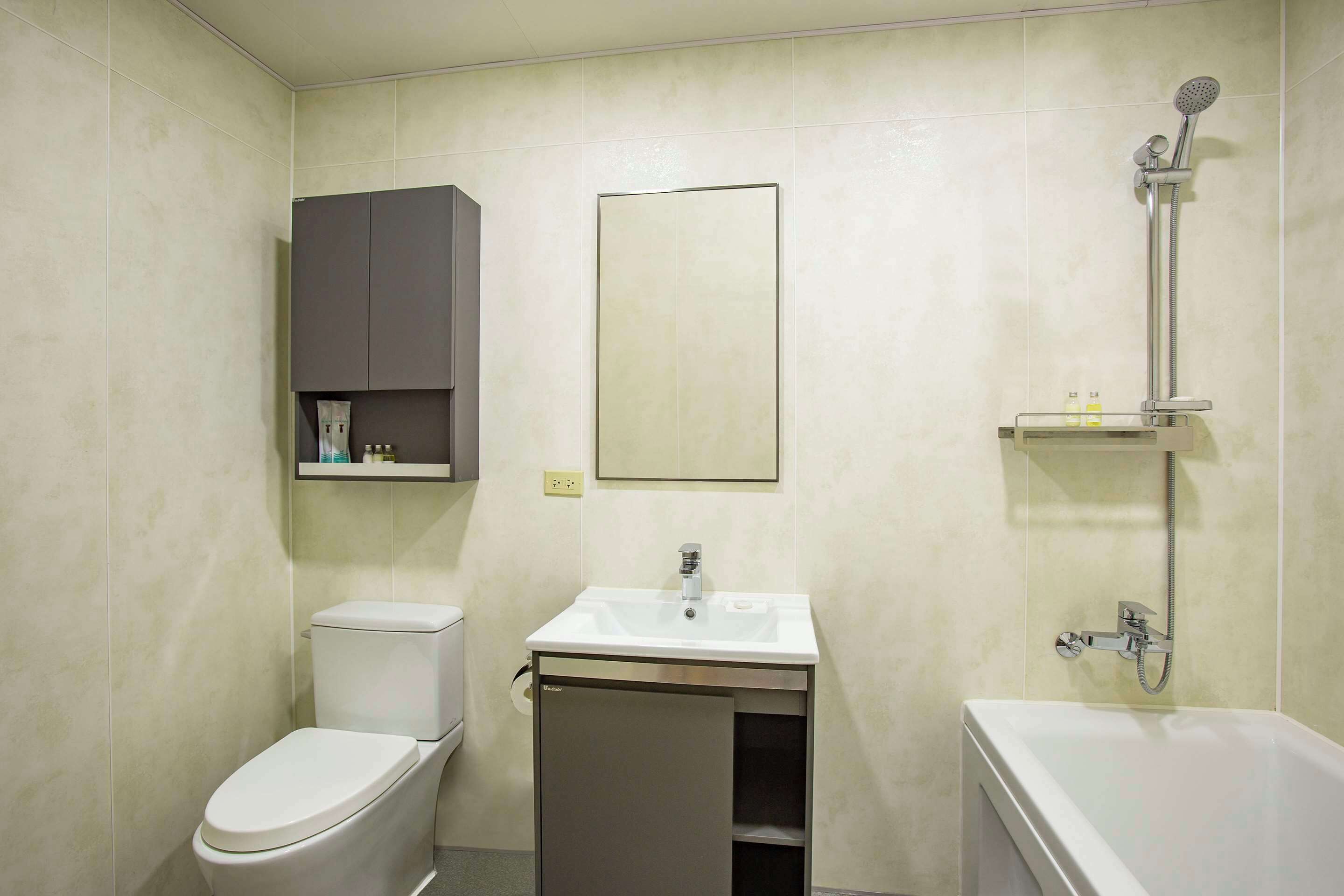 A bathroom with a toilet, sink, and shower.