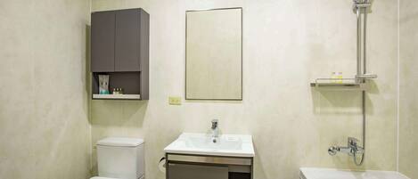 A bathroom with a toilet, sink, and shower.