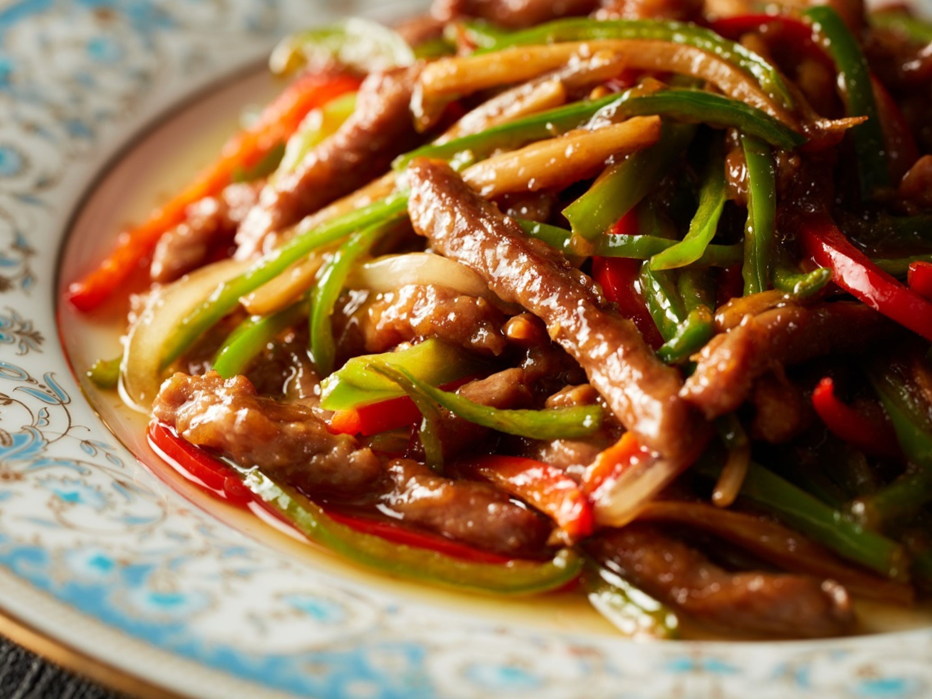 A close-up of a stir-fried dish with beef and vegetables.