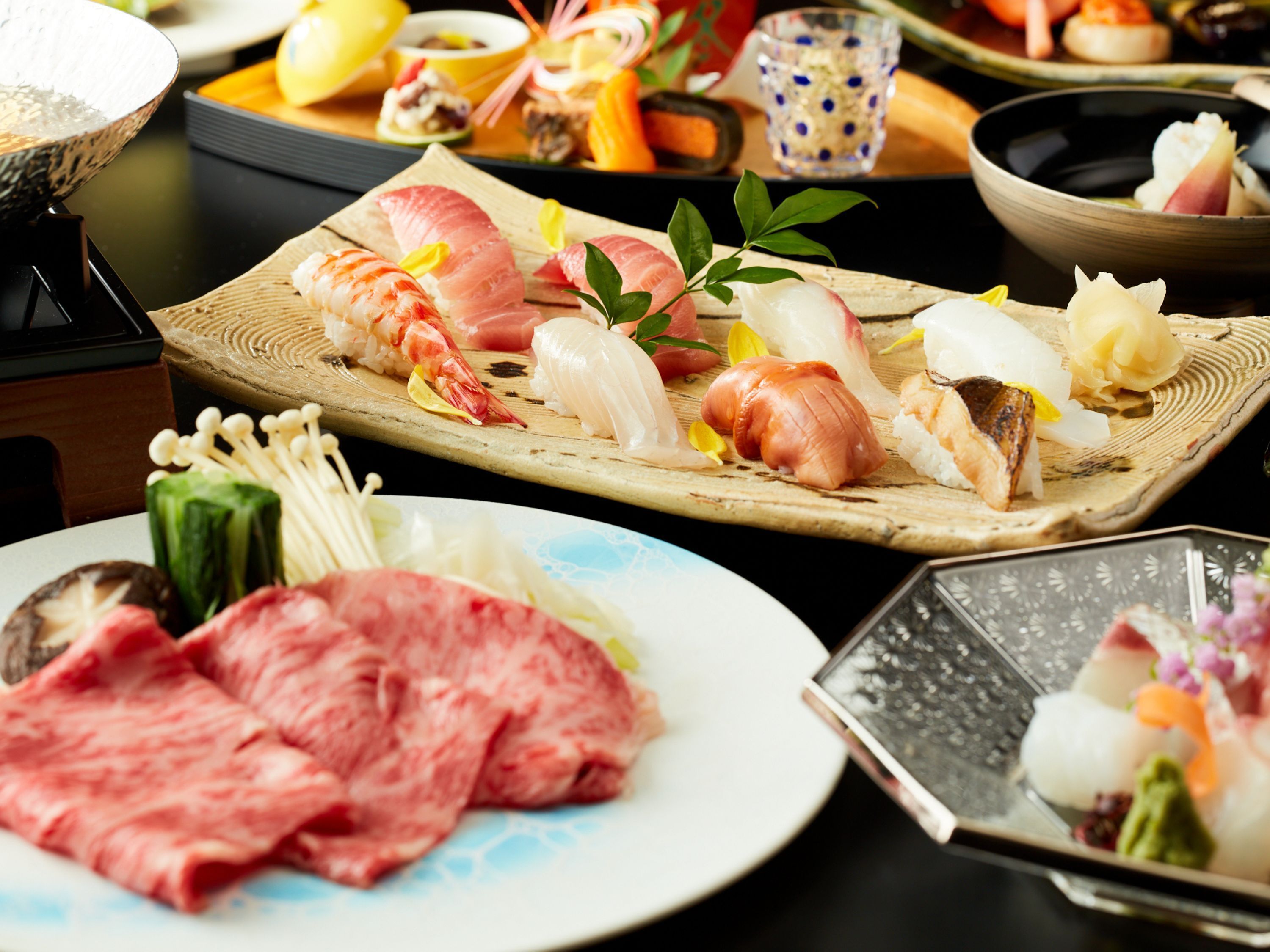 A variety of sushi and sashimi on a wooden tray.