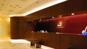 A reception area with a wooden reception desk, a laptop, and a reception sign.