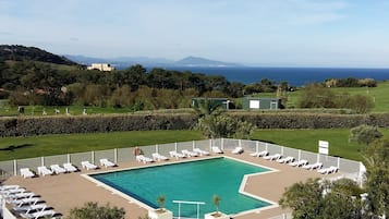 Una piscina al aire libre, tumbonas