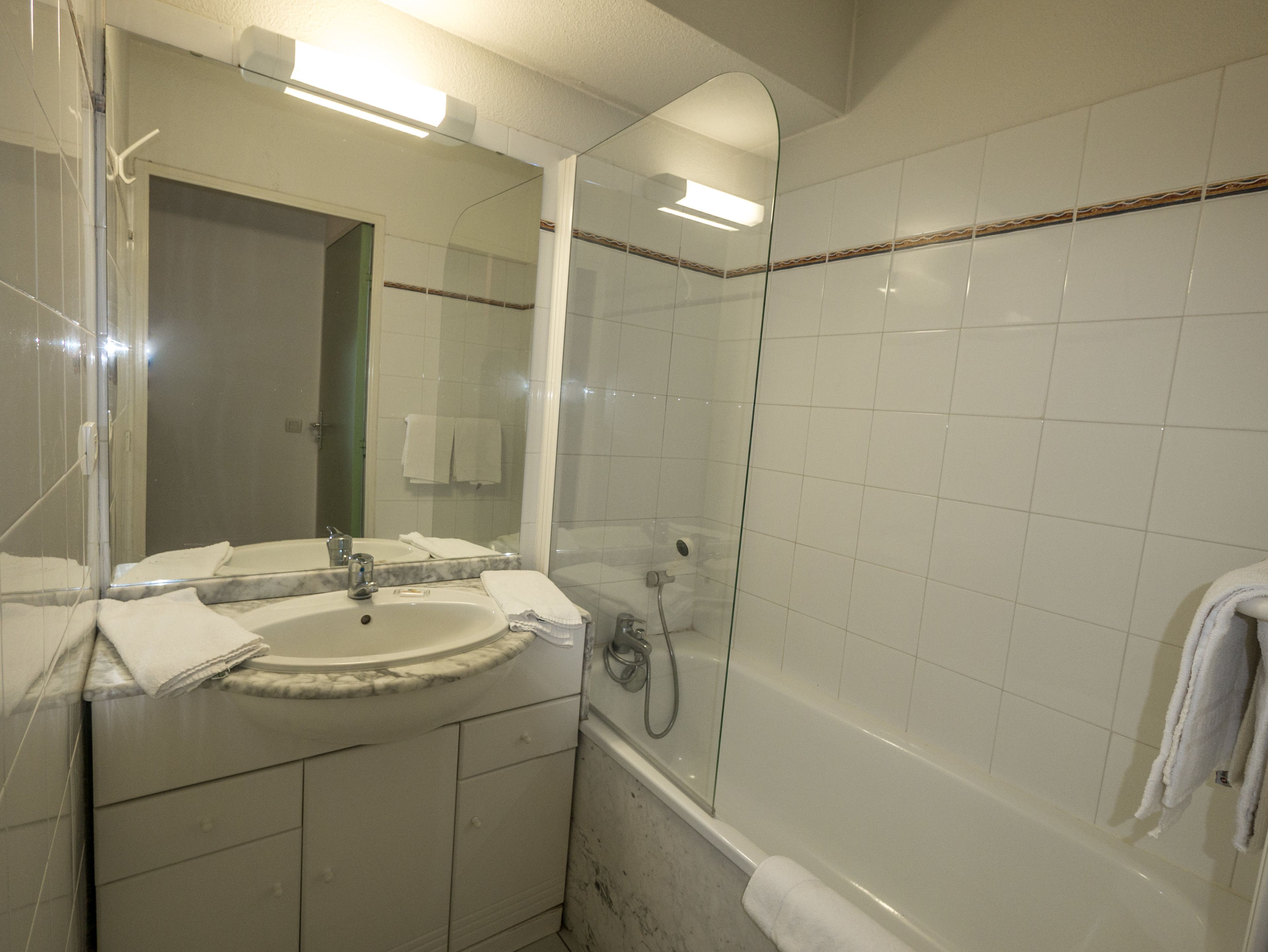 Une salle de bain avec un lavabo, un miroir et une douche.