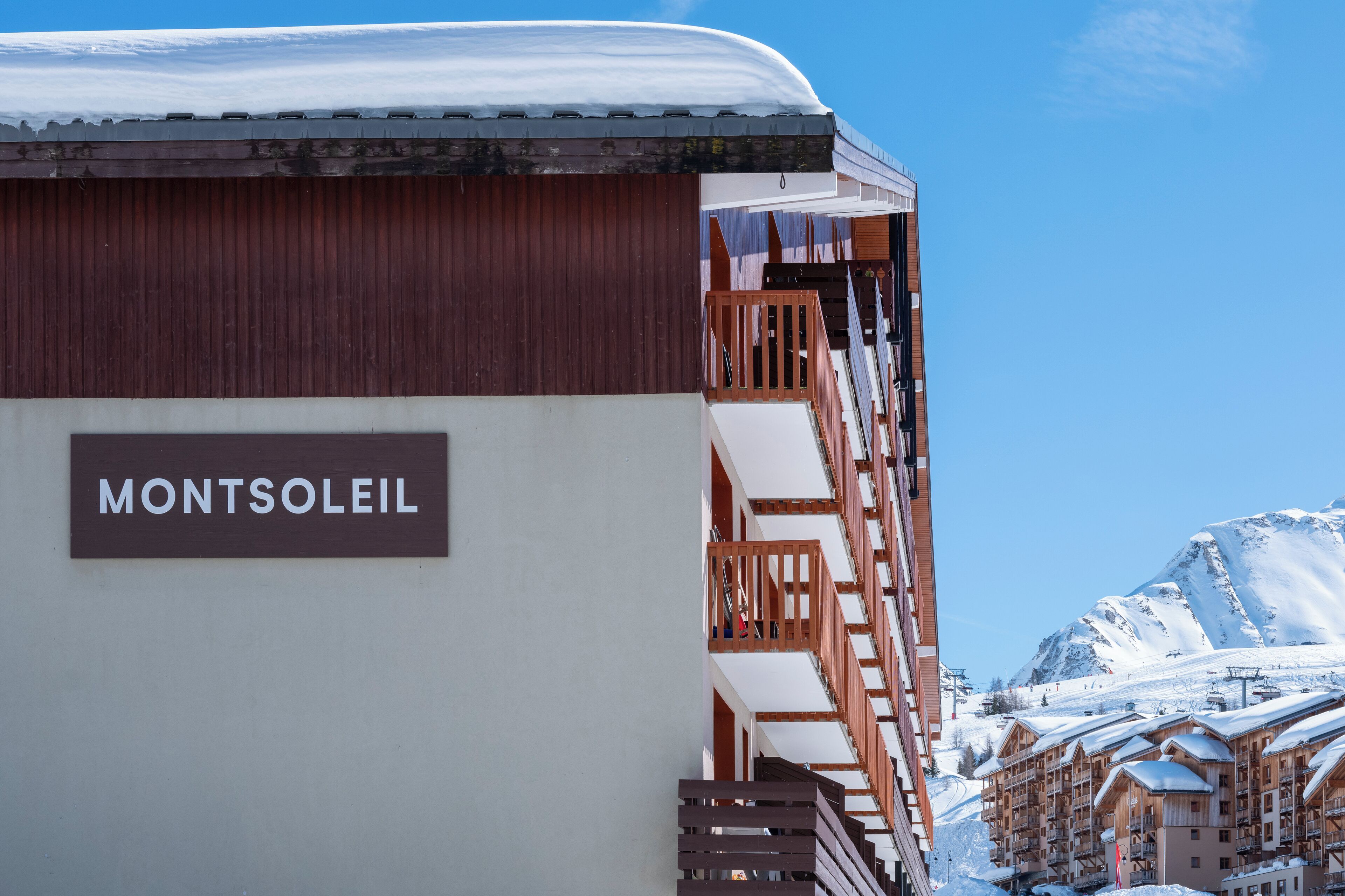 Rakennuksessa on kyltti, jossa lukee ”MONTSOLEIL”, ja siinä on puinen parveke.