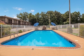 A rectangular swimming pool with a white fence, a number '5' on the ground, and a building in the background. - Best Western McKenzie (McKenzie)