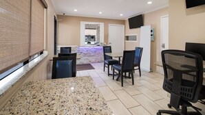 A hotel room with a dining area, a kitchen, and a TV mounted on the wall. - Best Western McKenzie (McKenzie)