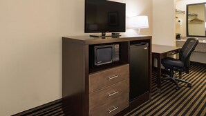 A hotel room with a flat-screen TV, a microwave, a mini-fridge, a desk with a chair, and a mirror. - Best Western McKenzie (McKenzie)