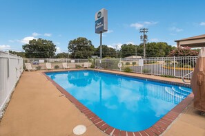 Una piscina al aire libre, sillones reclinables de piscina